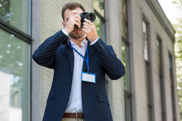 photojournalist in formal wear with press pass taking photo