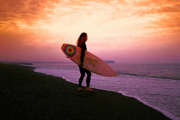 일출 전에 서핑 보드와 수석 여자 서퍼 - beach women joy sand 뉴스 사진 이미지