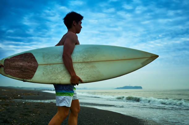 istock Young surfer on the beach at before sunrise 1011137704