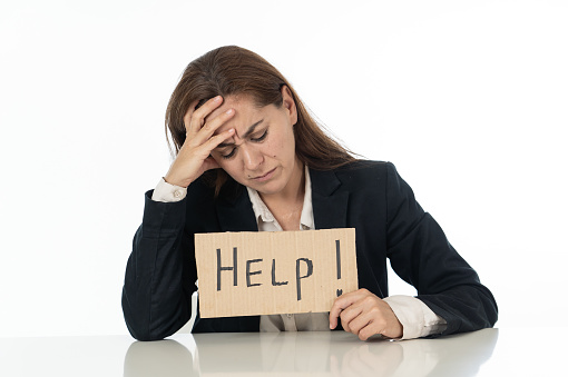 Young attractive frustrated and tired latin businesswoman holding help sign message exhausted, sad under pressure and stress isolated on white in unemployment depression overwork concept