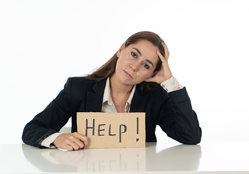 Young attractive frustrated and tired latin businesswoman holding help sign message exhausted, sad under pressure and stress isolated on white in unemployment depression overwork concept