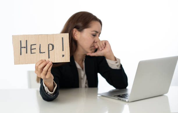istock Young attractive latin woman showing help sign desperate suffering stress at work while sitting at office laptop computer desk in business overwork female feeling stressed and overwhelmed. 1011146874