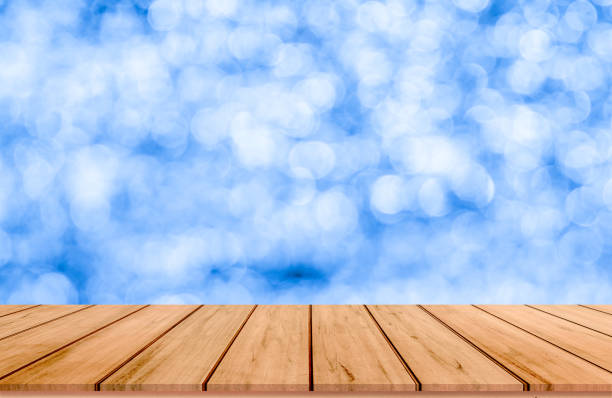 istock Wood plank with abstract blue blurred bokeh background for product display 1011155316