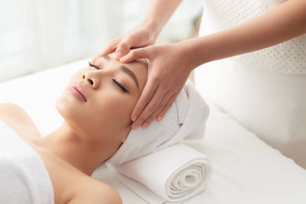 istock Massage therapist rubbing forehead of client 1011160406
