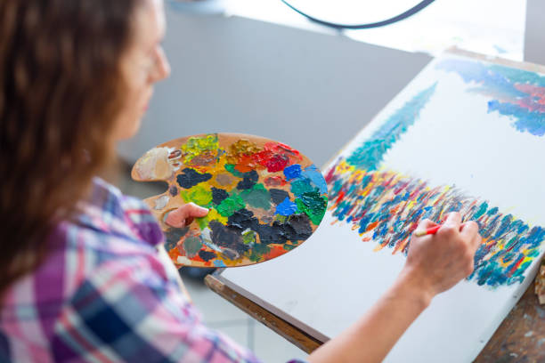 istock Young woman sitting and drawing 1011161020
