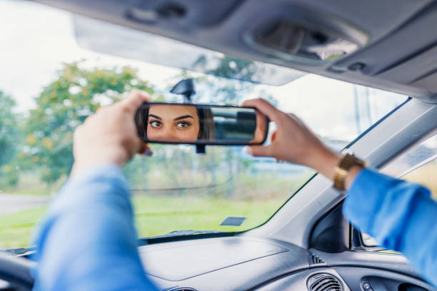 istock Woman adjusts the rear view mirror with her hand 1011170006