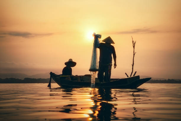 istock Fisherman on wooden boat. 1011172860