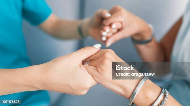 Old And Young Holding Hands On Light Background Stock Photo - Download Image Now - Patient, Care, Community Outreach