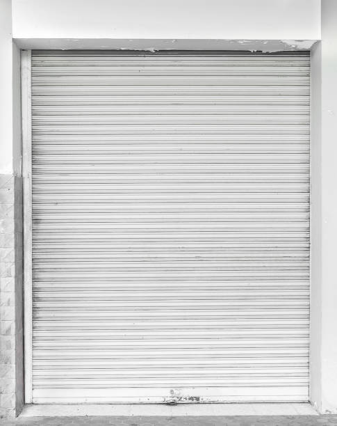 istock Old white metal roller shutter door. 1011181360