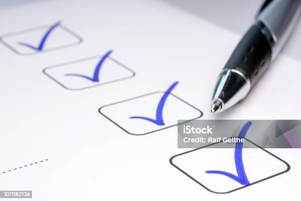 Check Off Completed Tasks On A Todo List Stock Photo - Download Image Now - Checklist, Quality Control, Check Mark