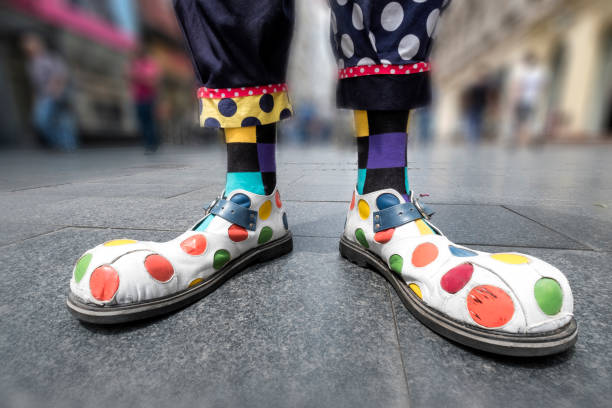 zapatos de payaso multicolor en la calle de la ciudad - interés humano fotografías e imágenes de stock