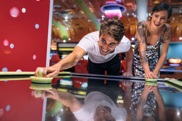 istock Couple playing air hockey game at a gaming arcade 1011186802