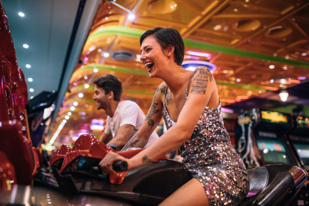 istock Happy couple having fun playing arcade racing games 1011187068