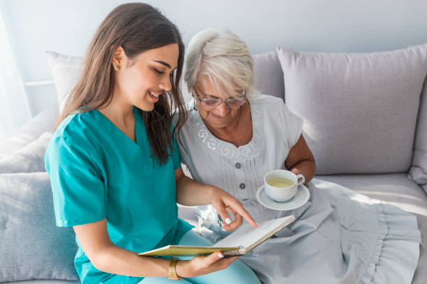 istock Senior care assistant reading book elderly woman 1011190226