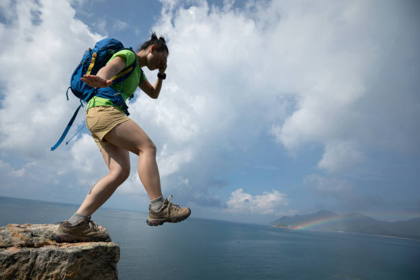 Woman walking over the edge of the cliff on seaside without looking Woman walking off of a cliff with the eyes covered walking beach women sadness stock pictures, royalty-free photos & images