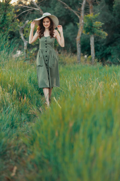 istock Beautiful woman in summer hat walking on grass 1011190970