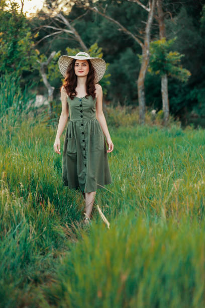 istock Beautiful woman in summer hat walking on grass 1011190988