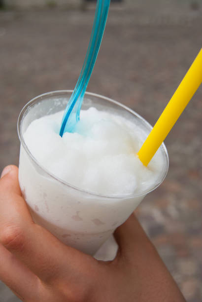 Person drinking and eating white lemon sicilian granita