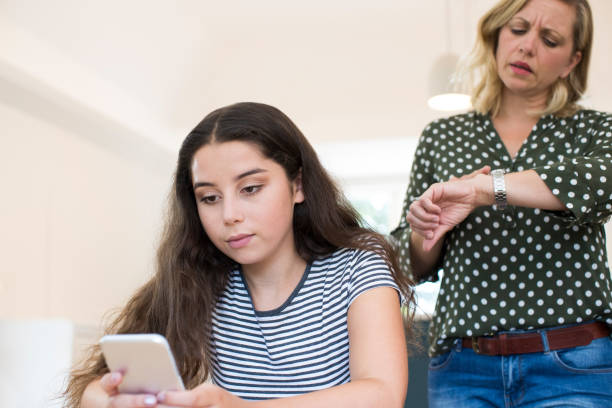 madre con hija adolescente respalda el uso de teléfonos móviles. - diferencia entre generaciones fotografías e imágenes de stock