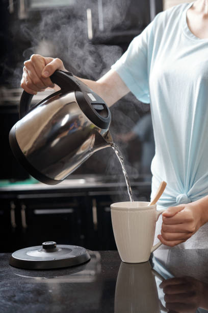 istock Crop lady brewing beverage in kitchen 1011195964