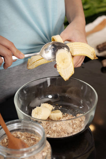 istock Crop female adding banana to oatmeal 1011197004
