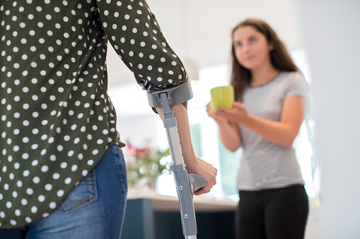 Teenage Daughter Making Drink For Disabled Parent