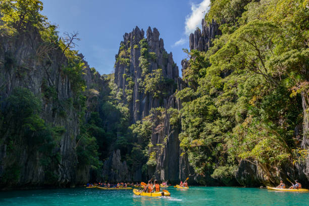 National Park and Reserve El Nido Palawan, Philippines. Tourists are kayaking in the small lagoon of Miniloc island stock photo