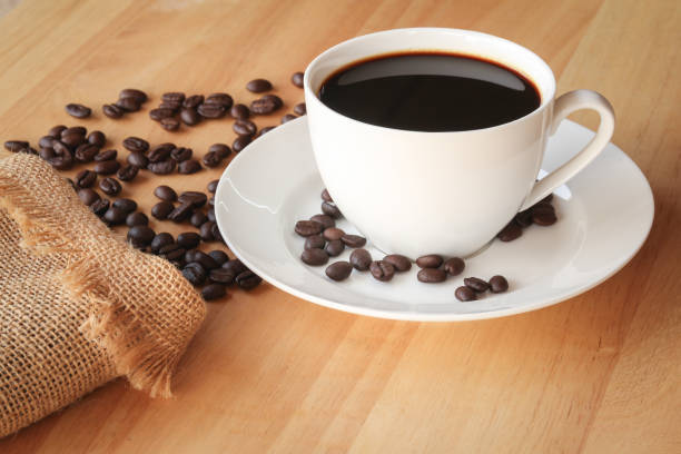 istock Coffee cup and coffee beans in sack on wooden background 1011205224