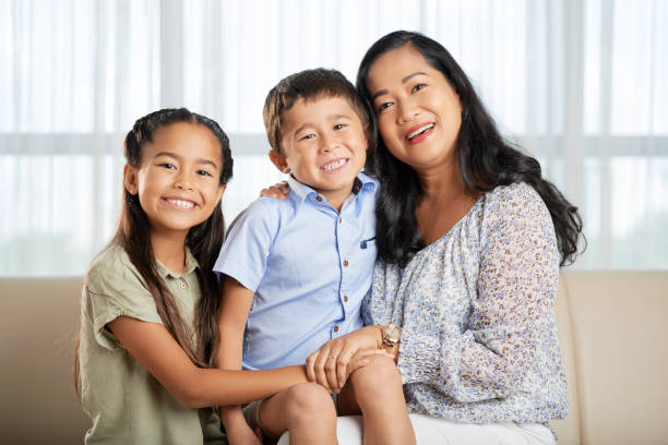 istock Asian mother and kids on couch 1011210672
