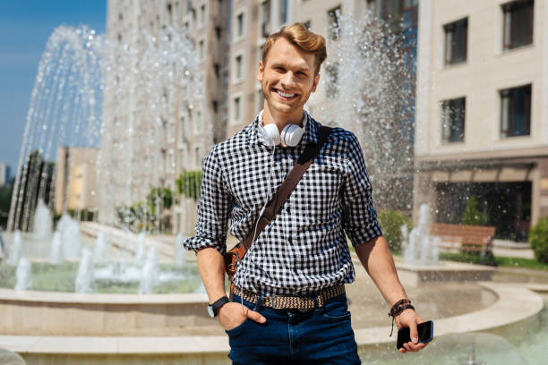 istock Joyful handsome man holding his smartphone 1011215628