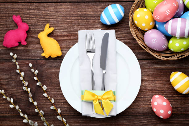 istock Kitchen cutlery with easter eggs and fabric rabbits on brown wooden table 1011216466