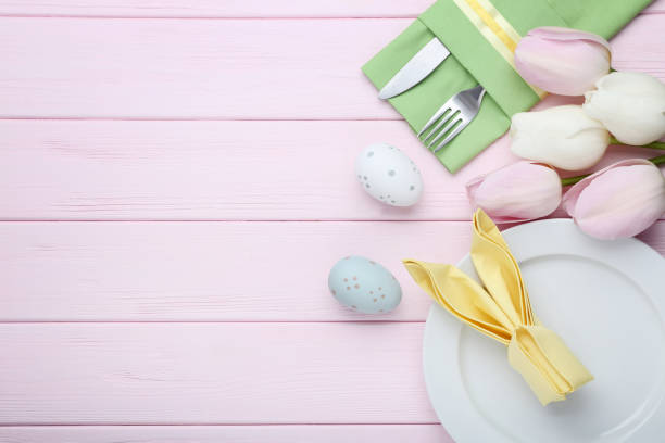 istock Kitchen cutlery with easter eggs and tulip flowers on pink wooden table 1011217574