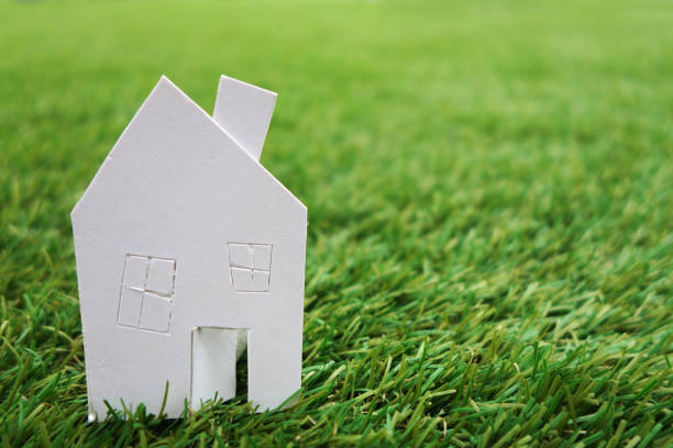 istock Paper house against on green grass 1011230792