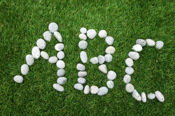 Letters A B C combined from white stones on green grass