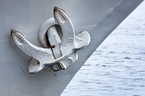 An image of part of the prow of a boat that holds the anchor in place with ropes and pulleys.