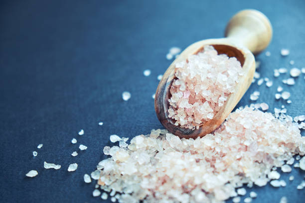 istock bowl of pink himalayan salt on dark table, top view, copy space 1011245154