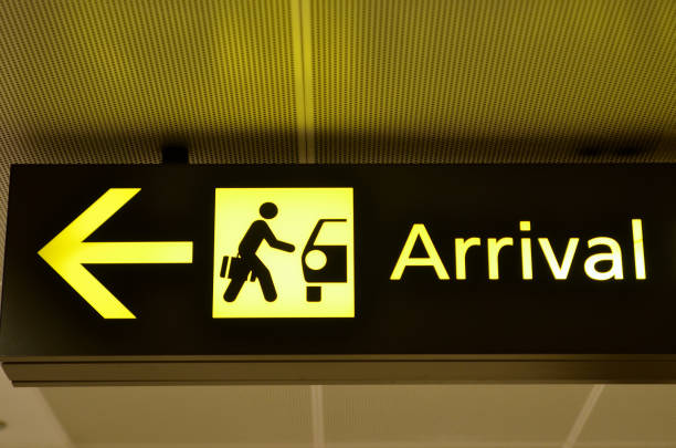 Airport arrival sign hanging from airport ceiling