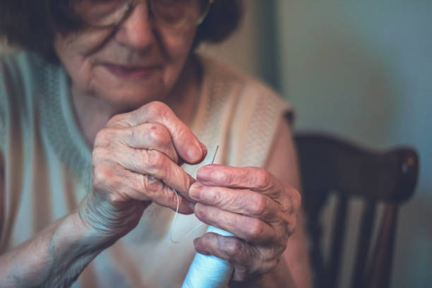istock Close up of old woman threading a needle. 1011250184