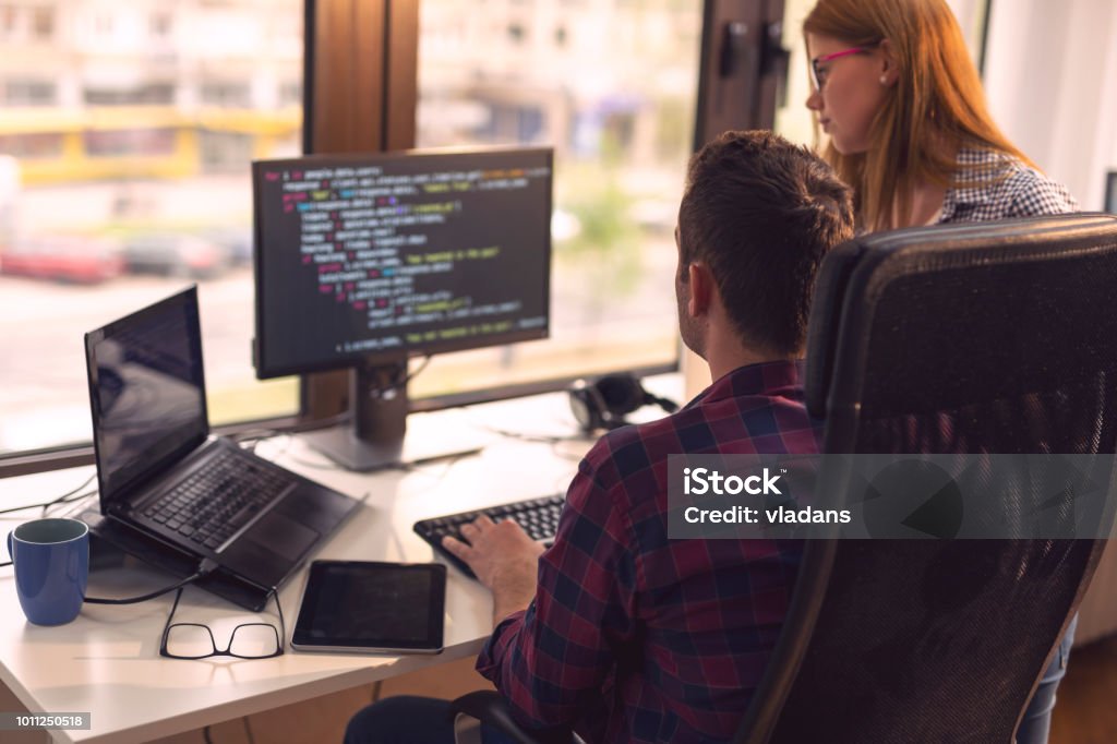 Senior developers working Two senior developers working in a software developing company office. Focus on the man sittig IT Support Stock Photo