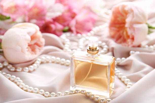 istock Perfume bottle with roses and bead on satin background 1011251414