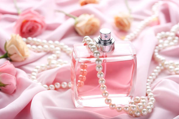 istock Perfume bottle with roses and beads on satin background 1011253862