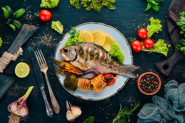 Baked fish carp. On a wooden background. Top view. Copy space.