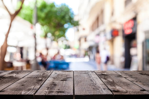 istock Empty wooden table with defocused sidewalk cafe at background 1011263552