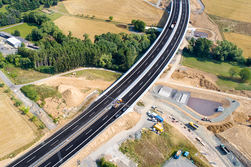Road through agricultural area, construction site, aerial view