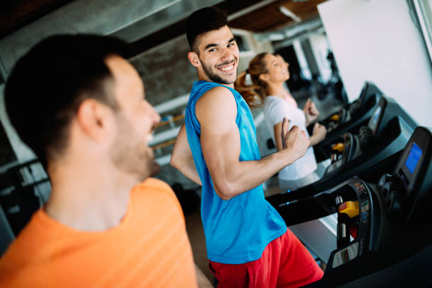 istock Happy people on treadmills in the gym 1011267232
