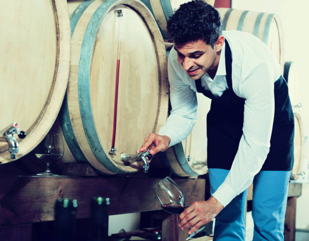 istock Seller pouring wine in cellar 1011268010