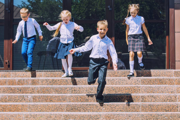 Beautiful school children active and happy on the background of school in uniform Beautiful school children active and happy on the background of school in uniform primary election photos stock pictures, royalty-free photos & images