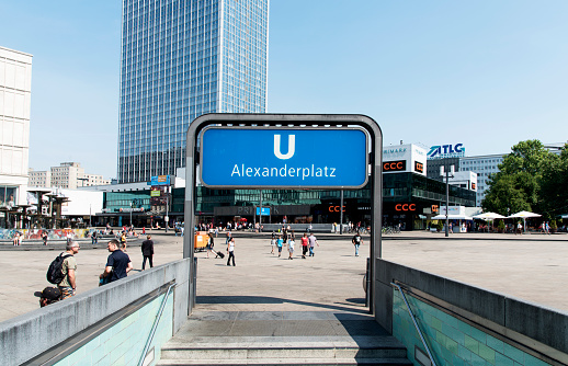 Berlin, Germany - May 28, 2018: A view of the Alexanderplatz square, a busy public pedestrian square in Berlin, Germany, with the entrance to the underground station in the foreground