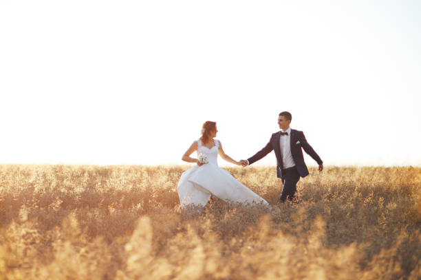istock Romantic Couple Walks Towards Sunset Holding Hands 1011270952