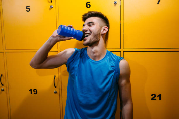 istock Handsome man drinking water in locker room 1011271410